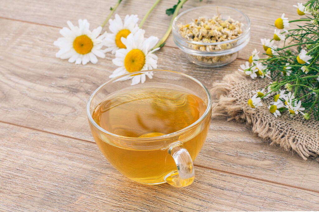 glass-cup-green-tea-little-glass-bowl-with-dry-flowers-matricaria-chamomilla-fresh-white-chamomile-flowers-sackcloth-wooden-background-1024x683